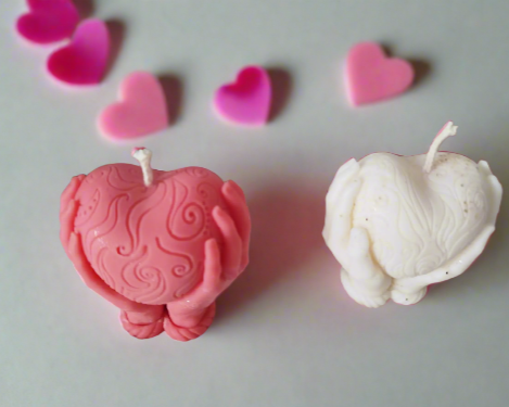 Bougie cœur entre mains- Douceur romantique en rose et blanc, décorée de mains tenant un cœur, sur fond de petits cœurs.