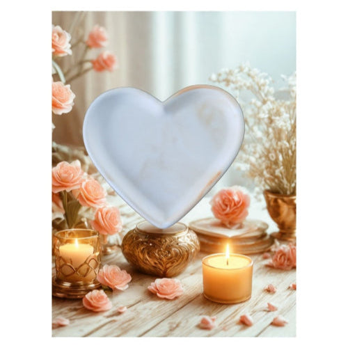 Aphrodite - Coupelle Cœur en Minéral Marbrée décorée avec des roses et des bougies pendant une ambiance chaleureuse.