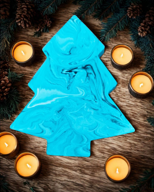 Décoration Sapin – Élégance et Magie de Noël avec un sapin bleu marbré et des bougies autour.