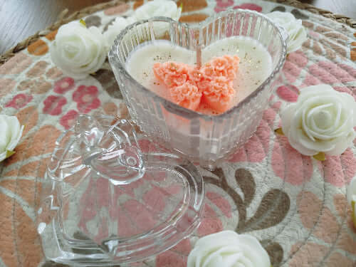 Bougie Papillon dans un élégant cœur en verre, ornée d'un papillon en cire.