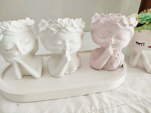 Objet déco rose fait main, représentant un visage féminin silencieux, ambiance douce et tendre