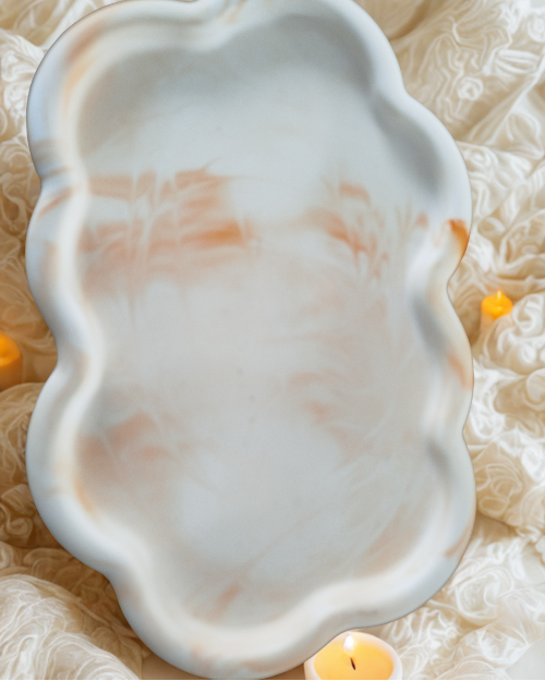 Gros plan sur les courbes du plateau décoratif Céleste. orange