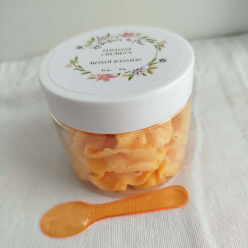 Pot de Fondant Crémeux Monoï Passion entouré de fleurs exotiques et de fruits de la passion