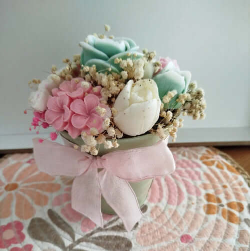 Bouquet de fondants en cire avec fleurs pastel et ruban rose en décoration