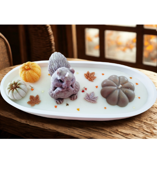 Centre de table automnal décoratif avec citrouilles, écureuil, et feuilles d'automne.