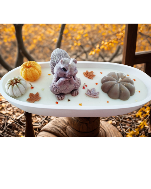 Centre de table automnal décoratif avec citrouilles, écureuil et feuilles, créant une ambiance chaleureuse.