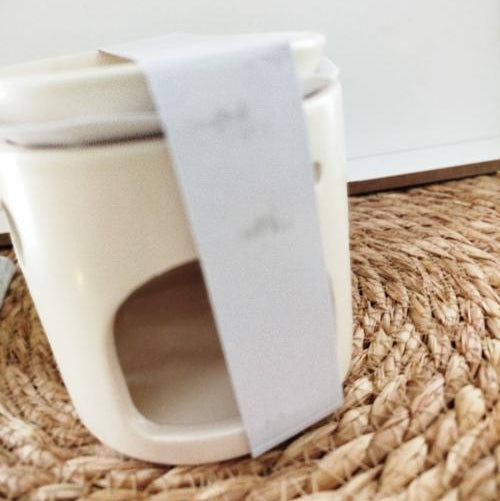 Brûleur Céramique avec Motifs Cœur Élégance Romantique sur une surface en osier, idéal pour diffuser des parfums.