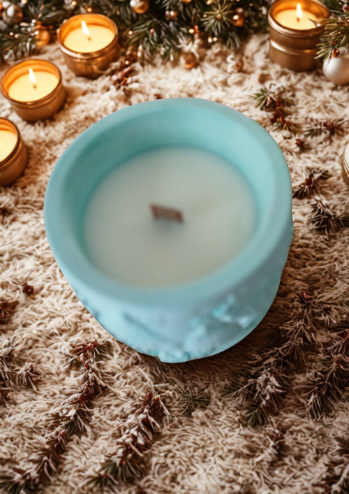 Bougie parfumé Forêt Enchantée en cire de soja, allumée dans une ambiance cozy, décorée de branches de sapin.