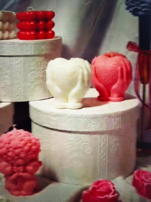 Bougie cœur entre mains- Douceur romantique en rose et blanc, décorée de mains tenant un cœur, sur fond de petits cœurs.