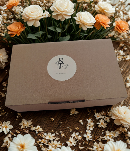 LOT DE 10 FONDANTS PARFUMES AUX SENTEURS VARIEES dans un emballage élégant entouré de fleurs.