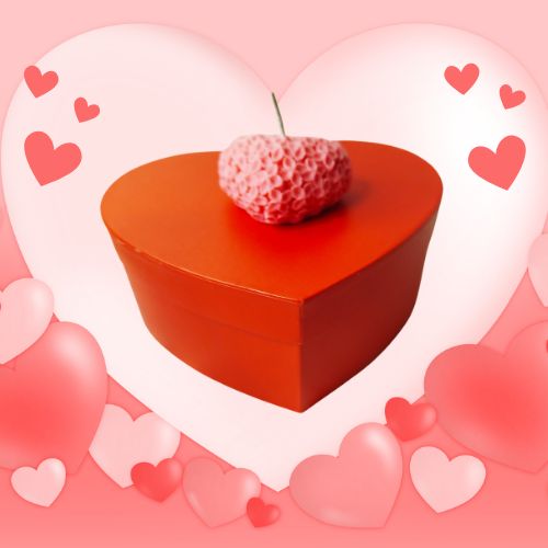 Bougie en forme de cœur sculptée  entourée d'un fond rose de petits cœurs, évoquant une ambiance douce et romantique