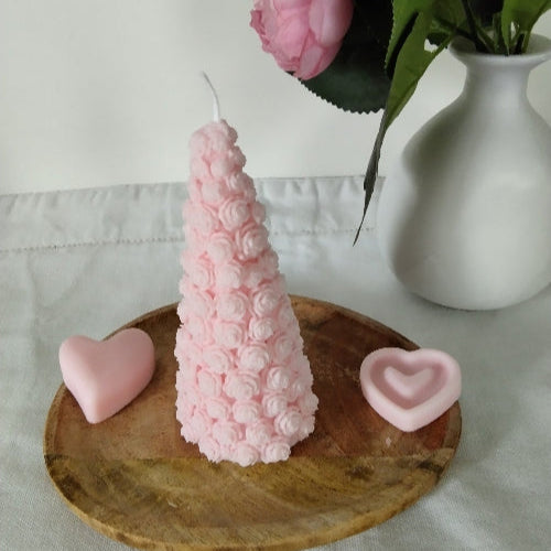 Bougie en cire végétale rose, sculptée en forme de bouquet de roses, élégante et parfumée.