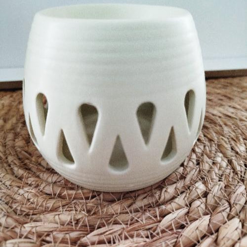 Brûleur de fondants en céramique blanche avec motifs en gouttes, design minimaliste.