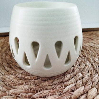 Brûleur de fondants en céramique blanche avec motifs en gouttes, design minimaliste.