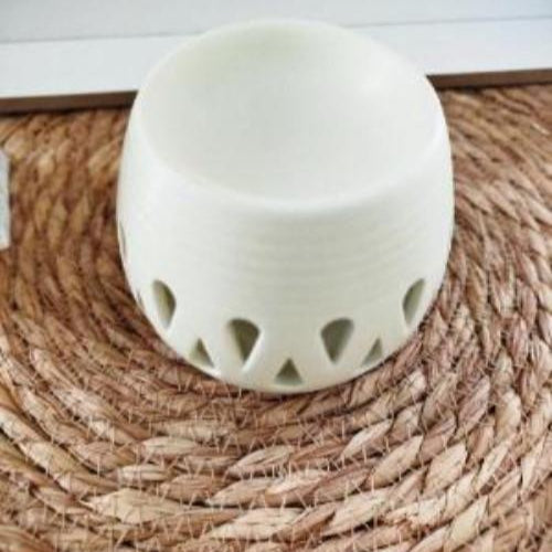 Brûleur de fondants diffusant un parfum, motifs en gouttes illuminés.