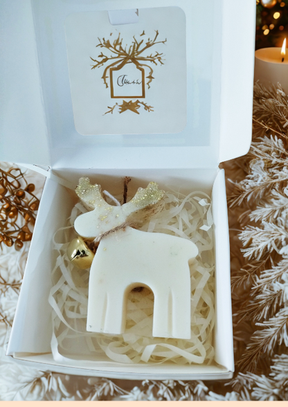 Bougie de Noël cerf parfumée emballée dans une boîte blanche avec paille naturelle, prête à offrir.