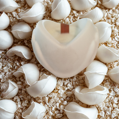 Bougie parfumée Cœur -Objet décoratif en résine fait main entourée de pétales blancs.