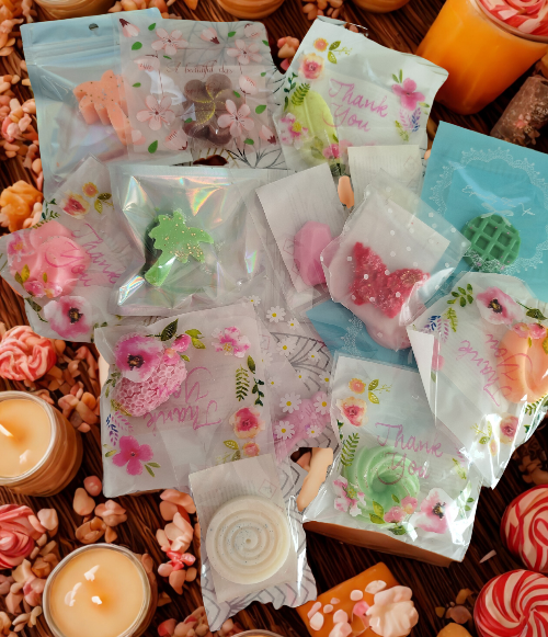 LOT DE 10 FONDANTS PARFUMES AUX SENTEURS VARIEES dans divers emballages colorés.