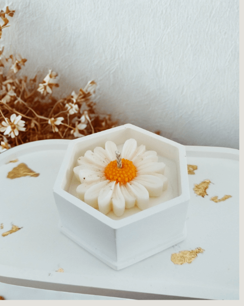 Bougie marguerite posée sur une table décorative