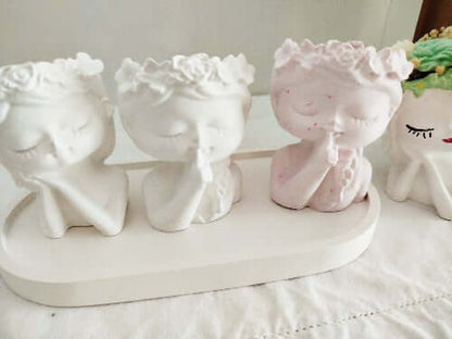Objet déco rose fait main, représentant un visage féminin silencieux, ambiance douce et tendre