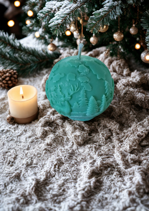 Bougies -Boules de Noël parfumées artisanales, l’une verte avec motifs de sapins et l’autre blanche pailletée, disposées parmi des décorations de fête rustiques.