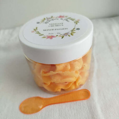 Pot de fondant Monoï Passion entouré de fleurs exotiques et de fruits de la passion