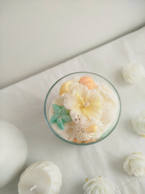 détail des fleurs pastel sur une bougie Monoï Pêche artisanale