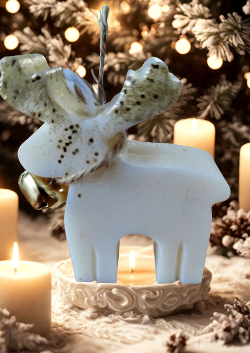 Bougie de Noël cerf parfumée façonnée à la main, décorée d’un grelot doré et présentée dans un décor hivernal.