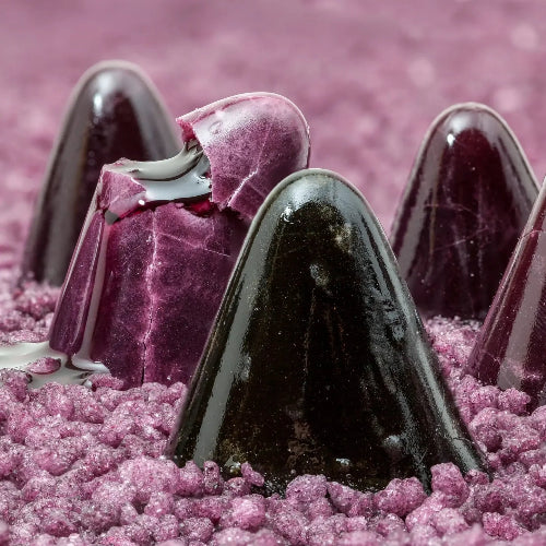 Fondant Parfumé Cuperdon displayed on a bed of colorful edible sugar, resembling a sweet treat.